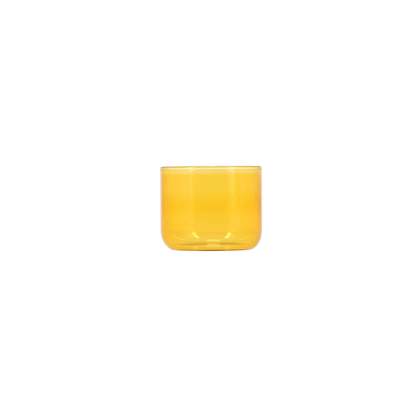 Lavt cylindrisk drikkeglas i en ravgul nuance.